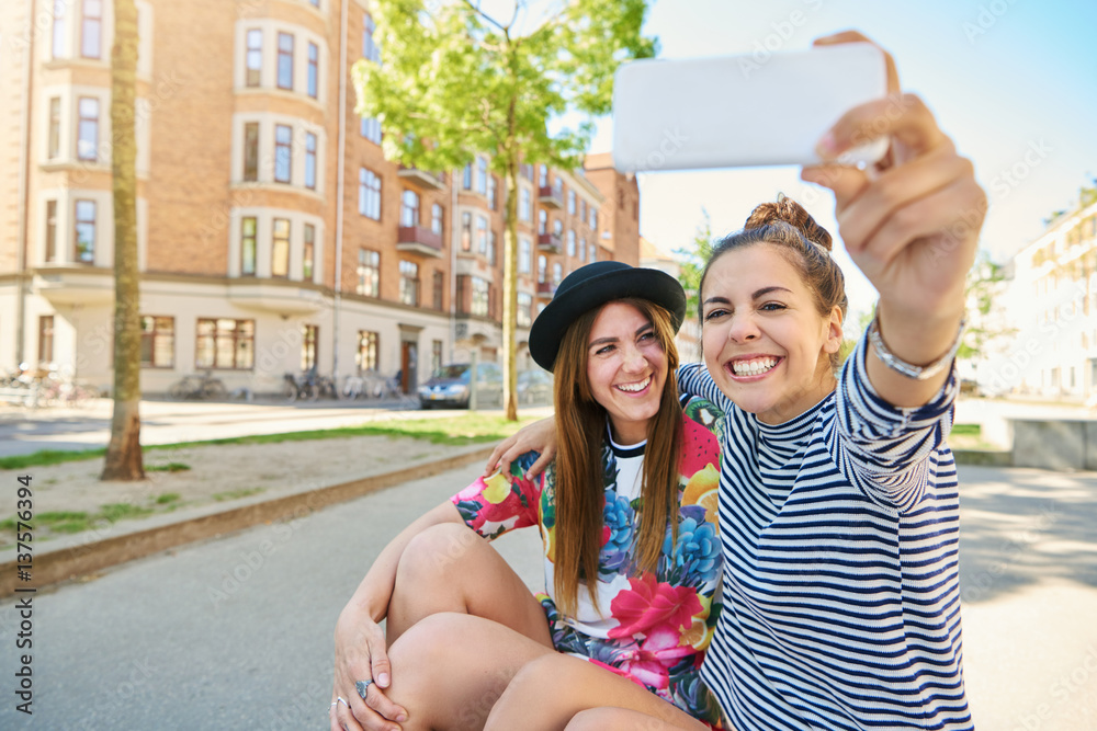 Two happy young women taking their selfie