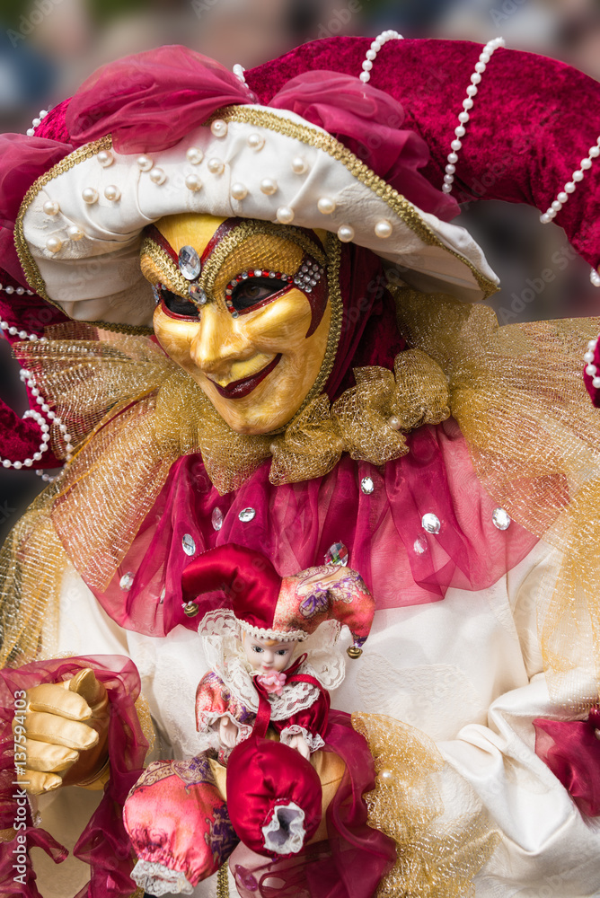 Masque de venise et costume de carnaval. Ton doré et rouge. Masque doré. Visage souriant.