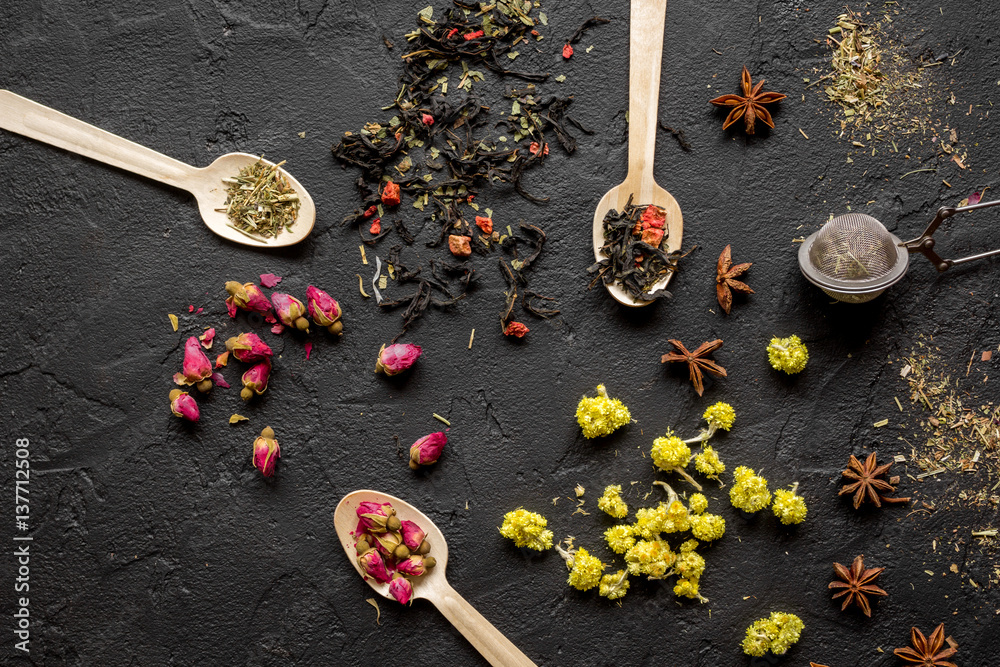 Herbs on spoons black background top view