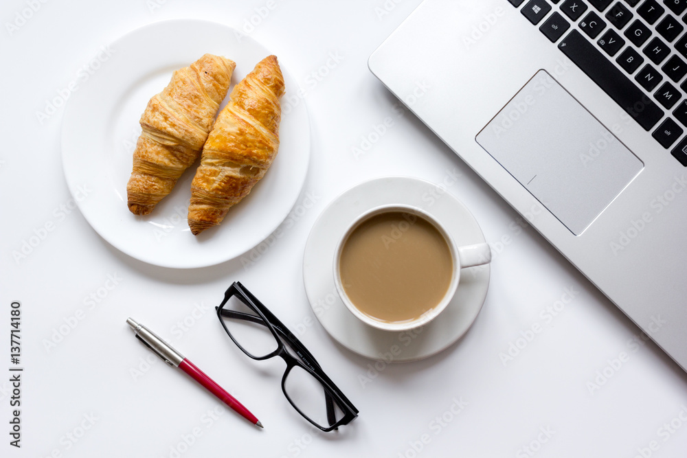 Coffee break in office on desk with laptop top view