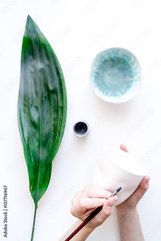 painted ceramic cup on white background top view