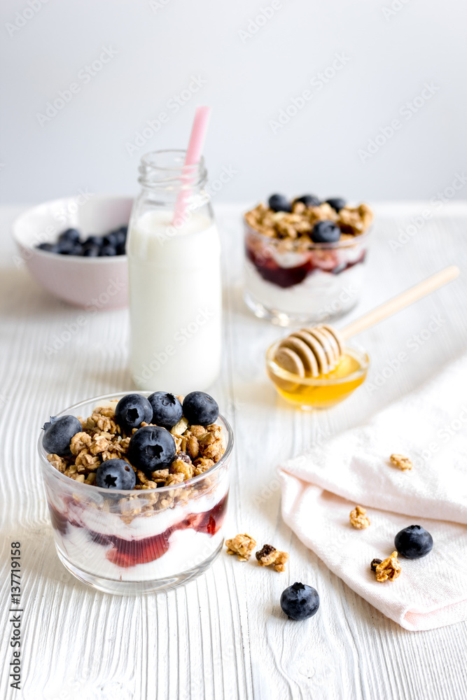 Cooking breakfast with granola and berries on white kitchen background