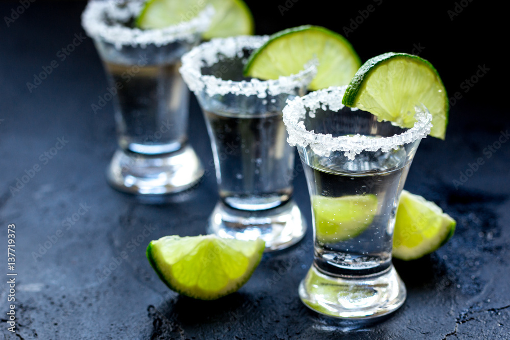 Alcohol shots with lime and salt on black background