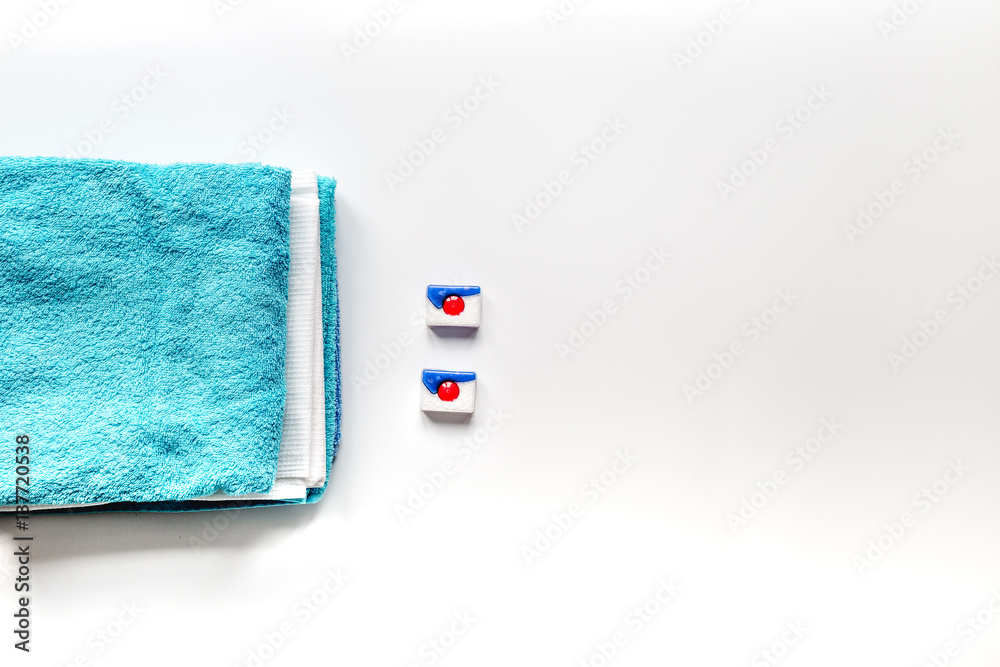 Pile of towels with detergent on white background top view mock up