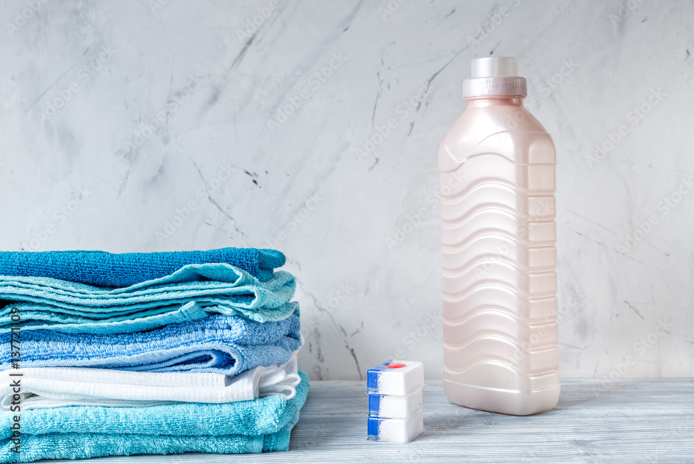 Pile of towels with detergent on laundry background mock up