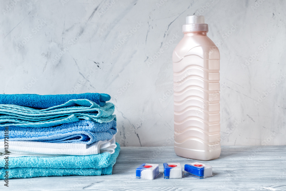 housekeeping set with towels and plastic bottles on laundry background mock-up