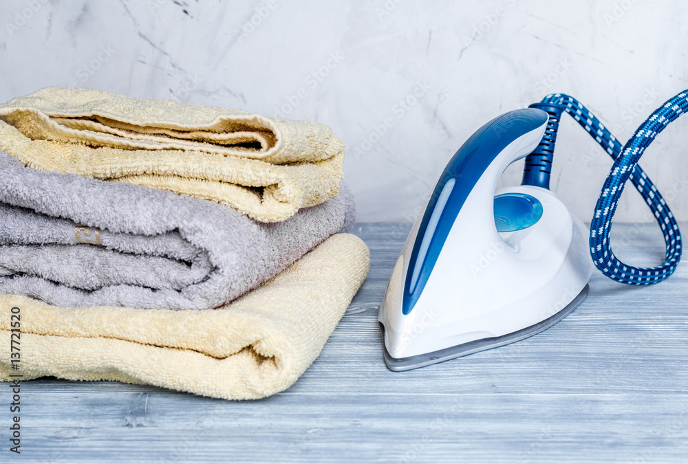 Launry set with towels and iron on gray background