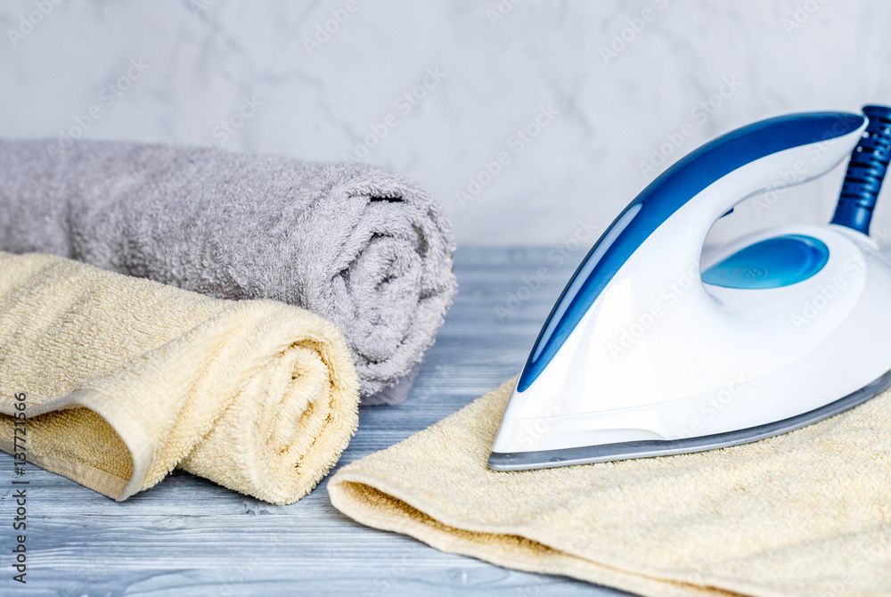 Launry set with towels and iron on gray background