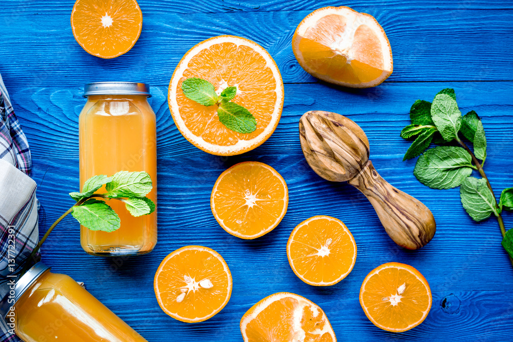 Orange juice in bottle with slices and mint on table top view