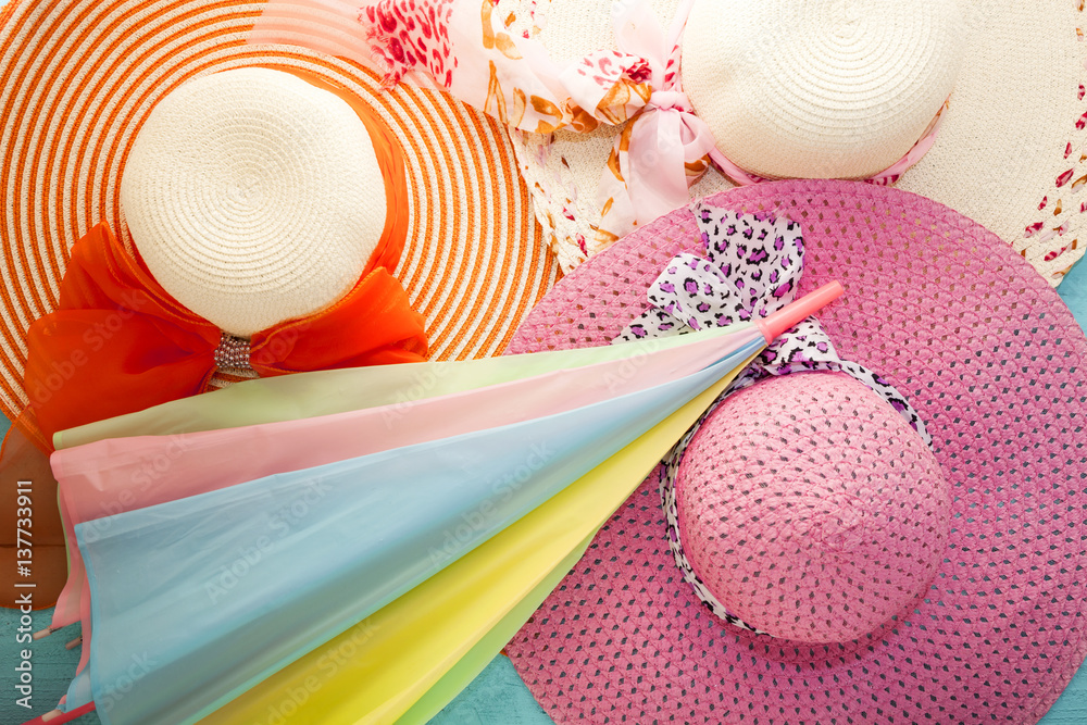 colorful lady hat and umbrella on wood.