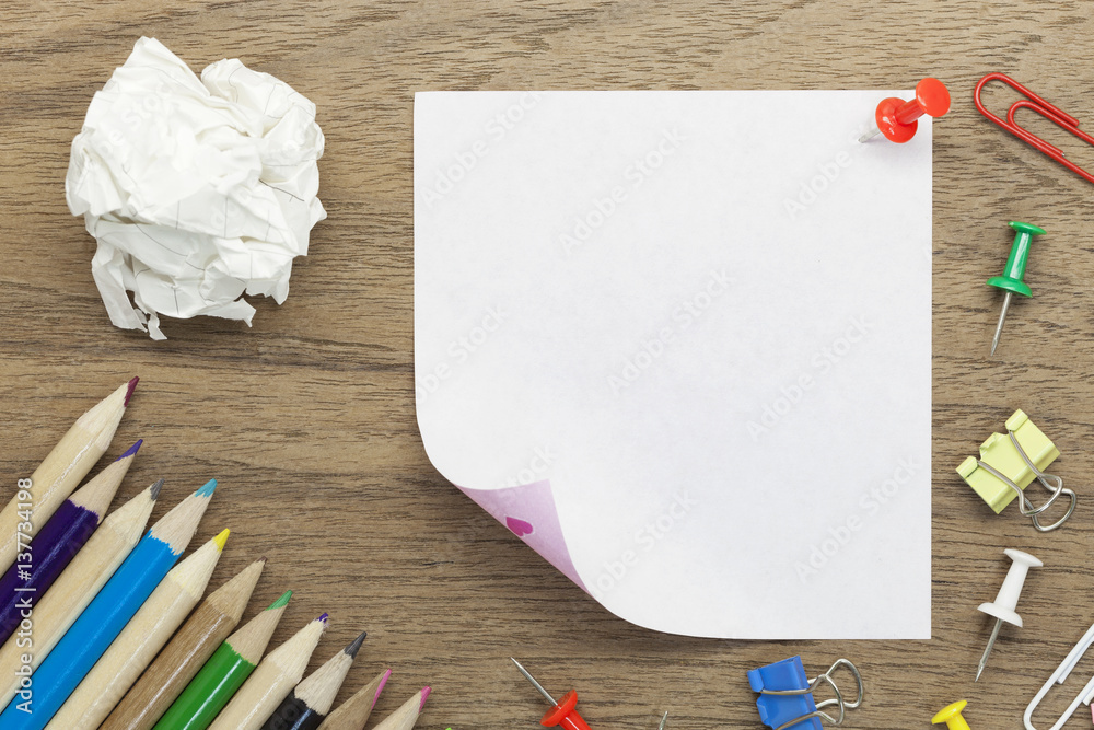 blank white paper note with school office supplies on wood desk.