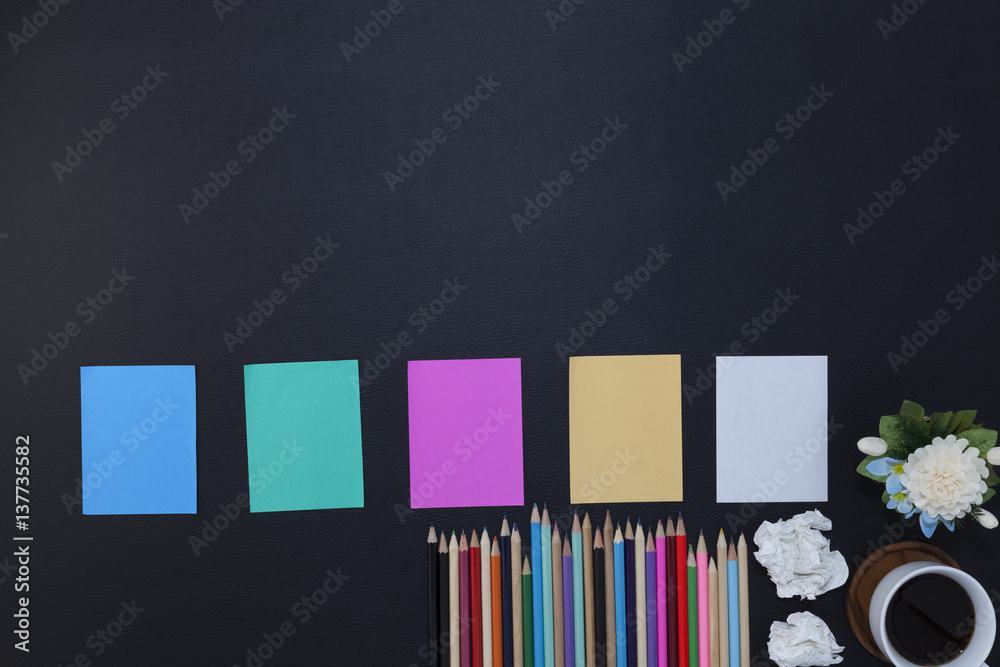 colorful paper note with pencil and coffee cup,flower on black leather table.Top view with copy spac