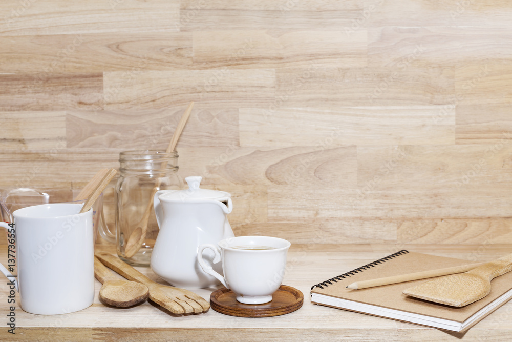 Coffee cup with glass bottle and empty measuring cup,wooden spoon on wood background.