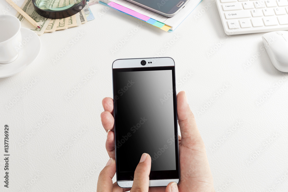 hand use smartphone with office white leather desk table and Business workplace and business objects