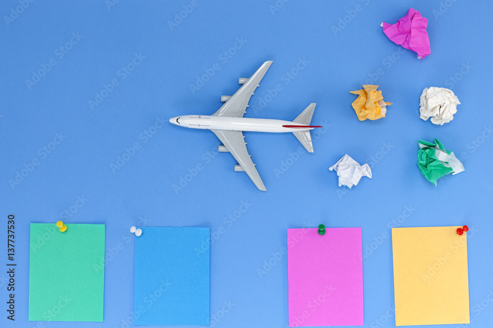 Airplane model with colorful blank paper note on blue background, picture for add text message or us