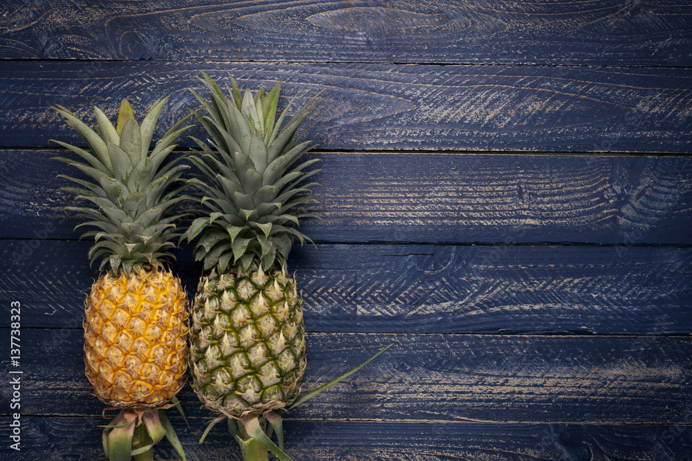 pineapple fruits on blue wooden floor background.