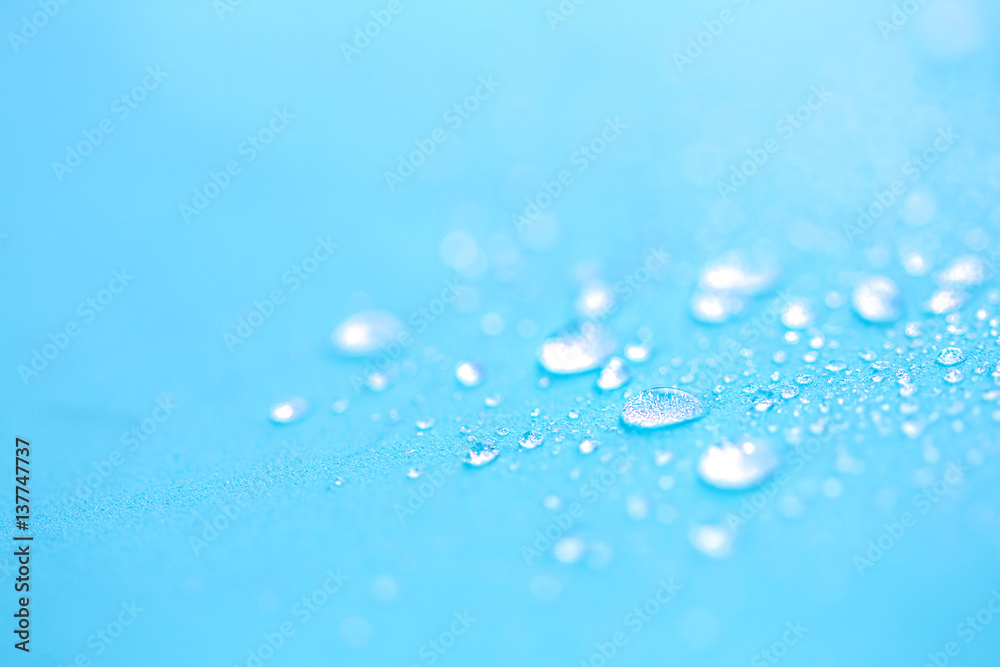 Close up rain water drops on blue sponge surface as abstract background