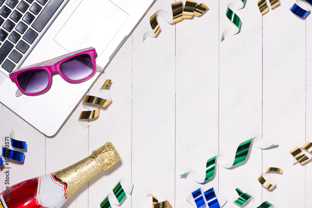 Celebration Flat lay. Champagne bottle and laptop with copyspace on wooden background