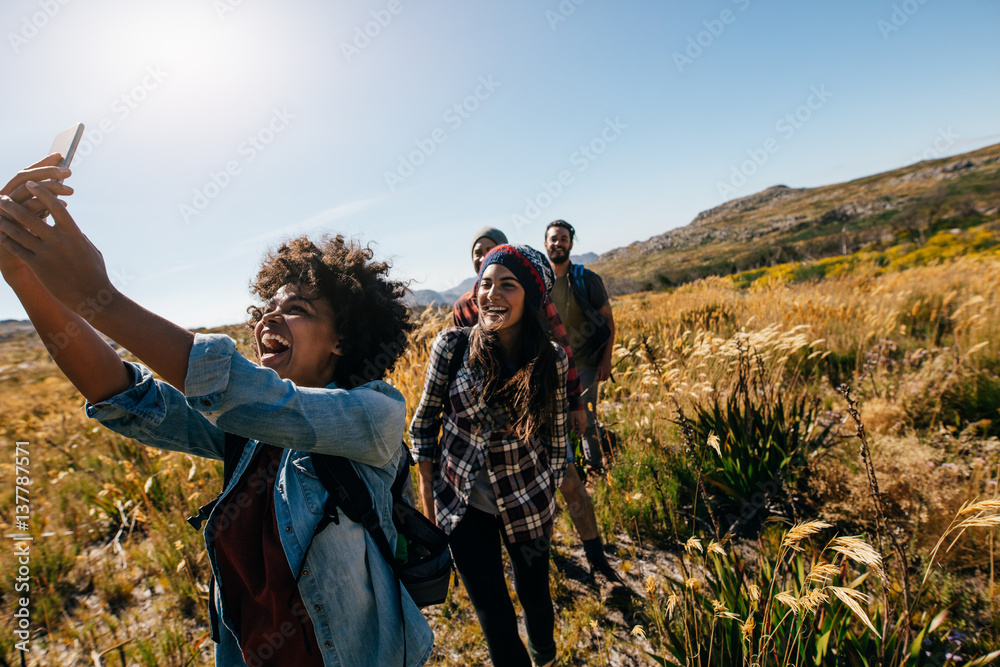 Woman taking pictures of friends while hiking