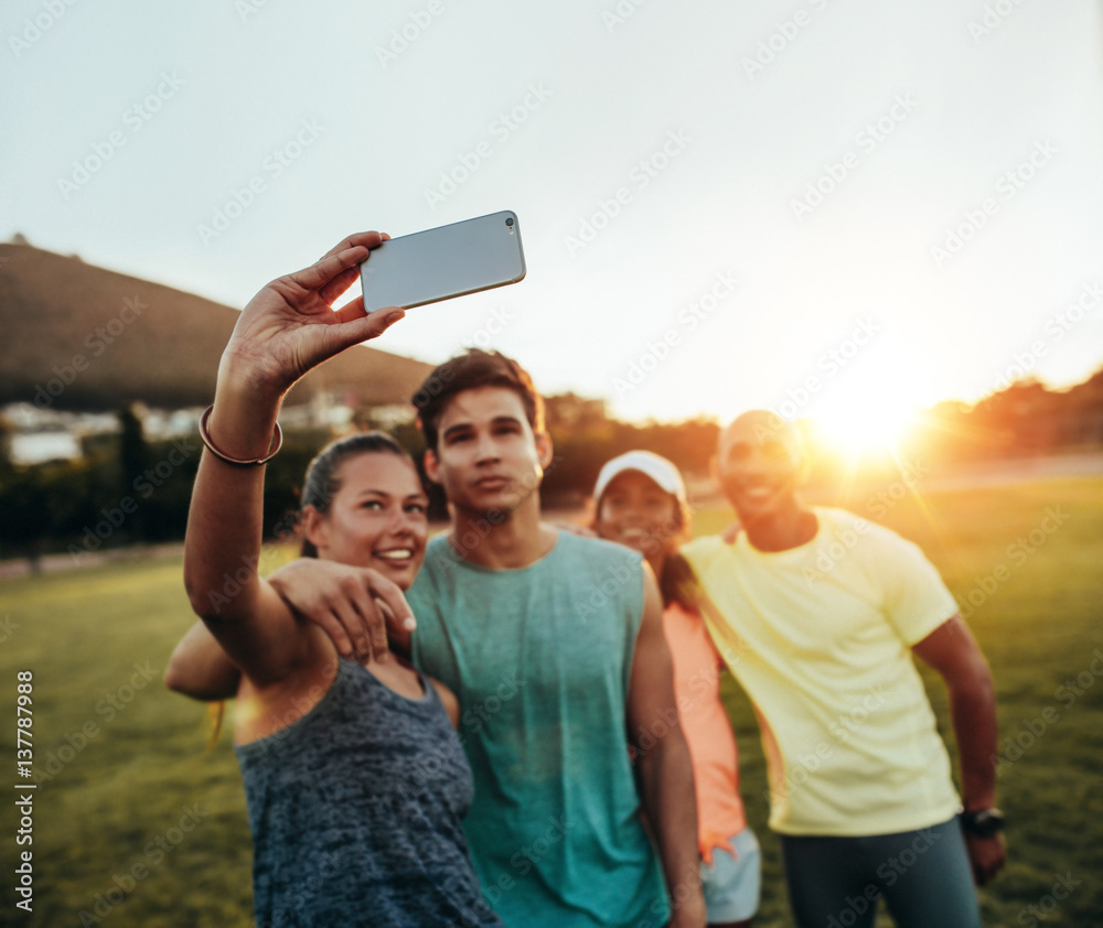 Group of runners taking selfie at park