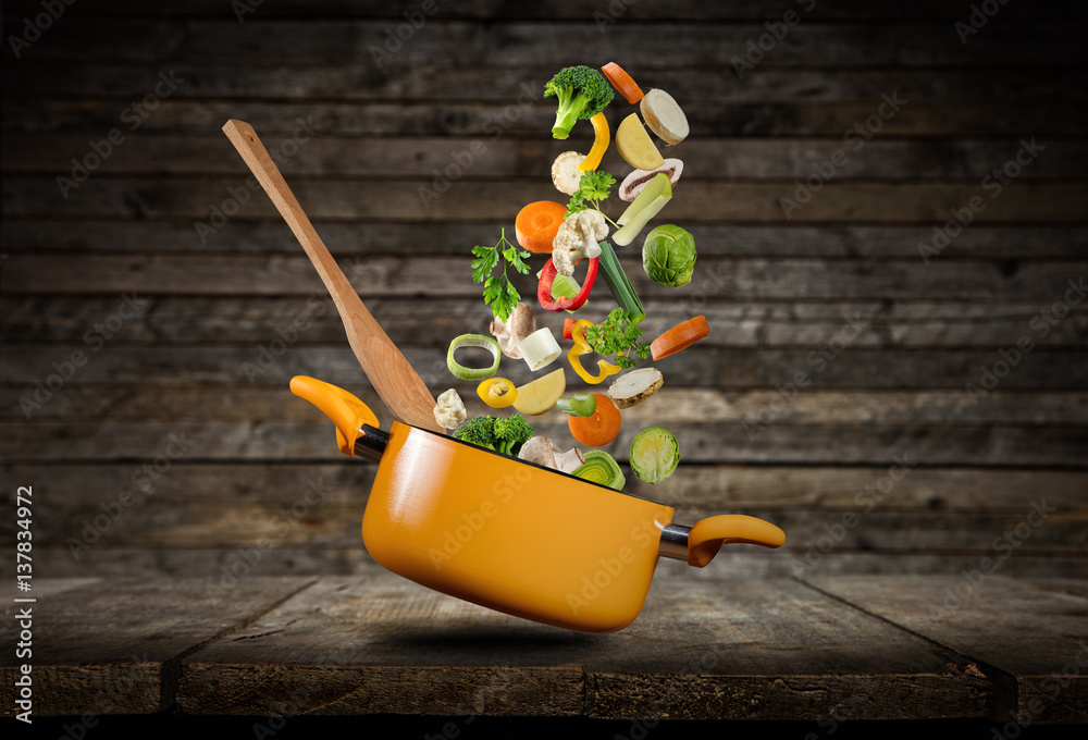 Fresh vegetables flying into a pot