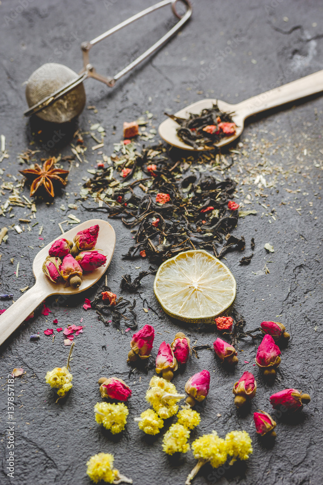 Spoons and herbs on grey background