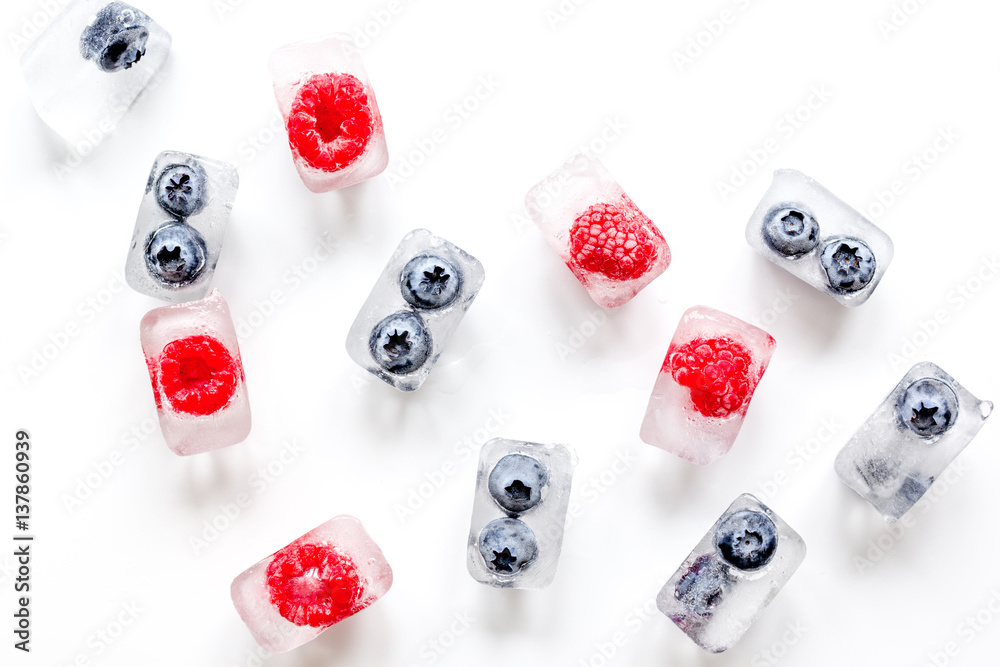 ice cubes with fresh berries on white background top view