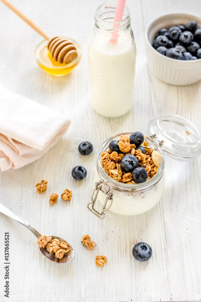 Fitness breakfast with granola, milk and honey on white background