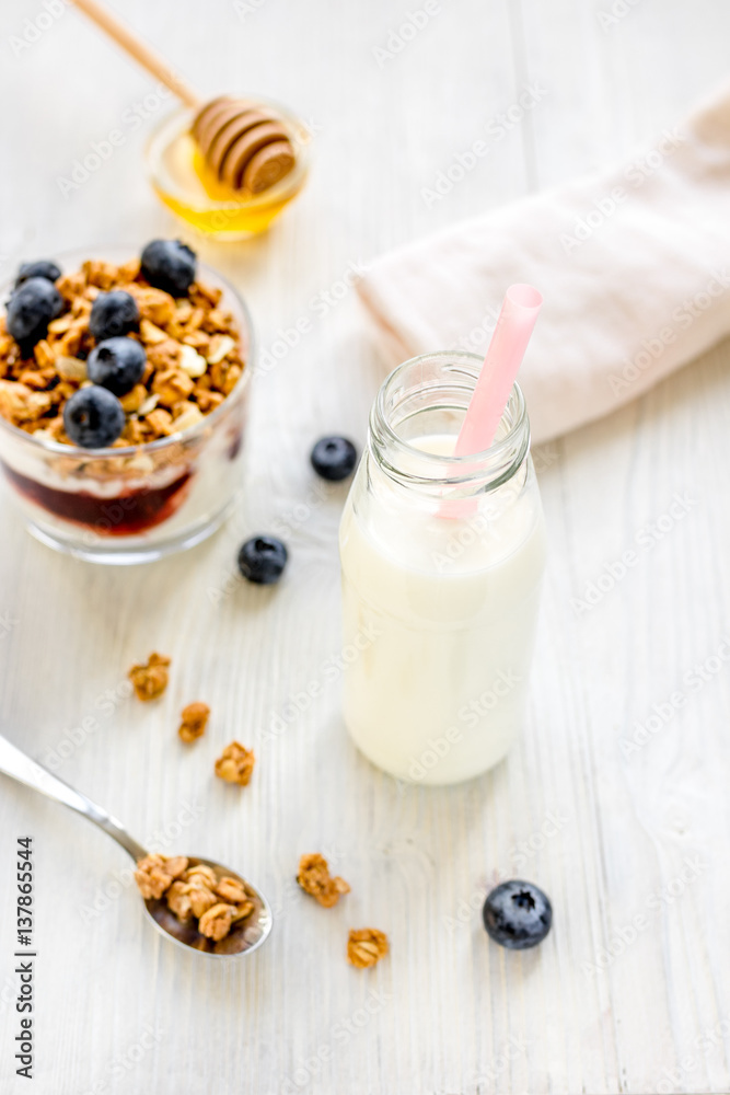 Fitness breakfast with granola, milk and honey on white background