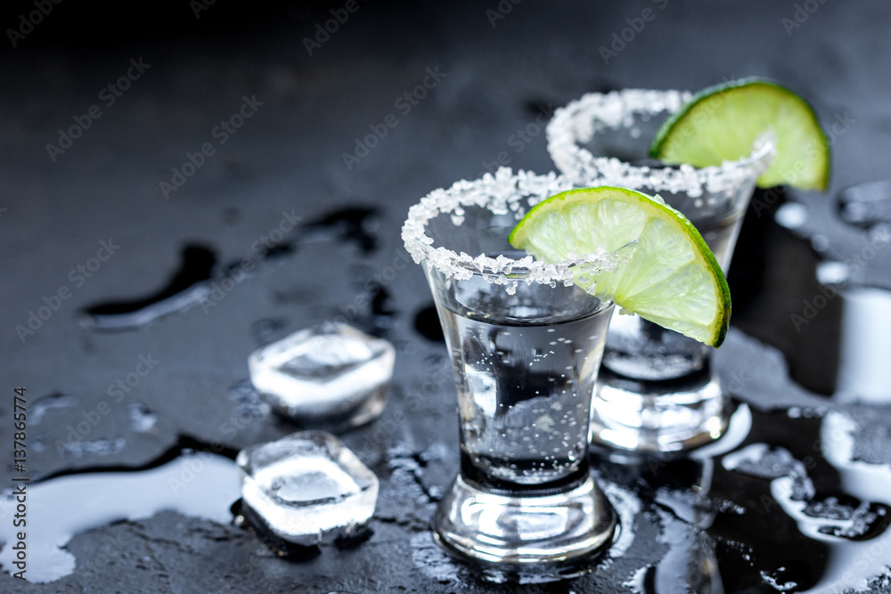 Alcohol party with tequila, ice and salt on black background