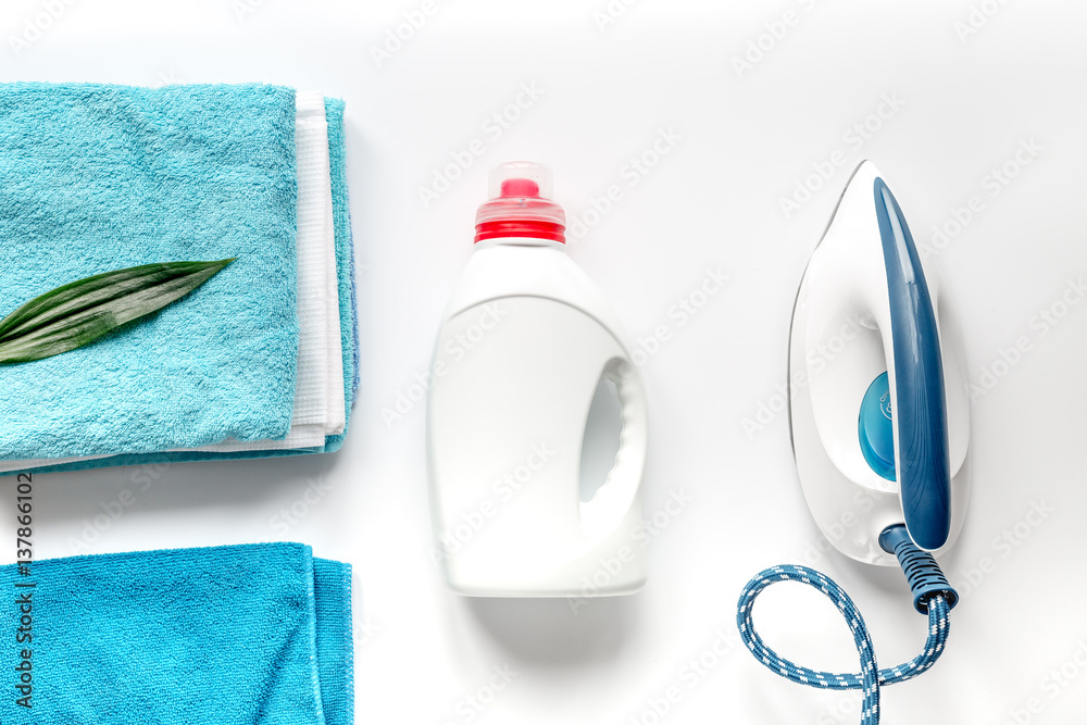 Launry set with towels and iron on white background top view