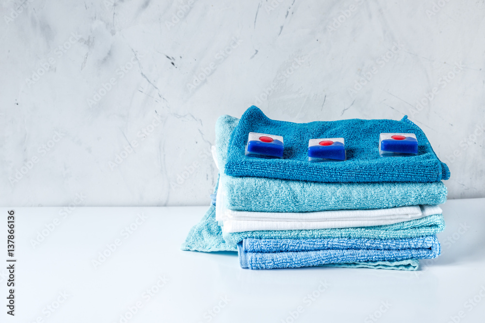 Pile of towels with detergent on laundry background mock up