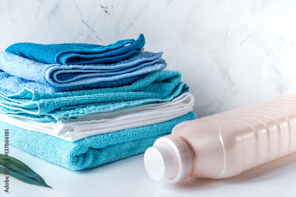 housekeeping set with towels and plastic bottles on laundry background