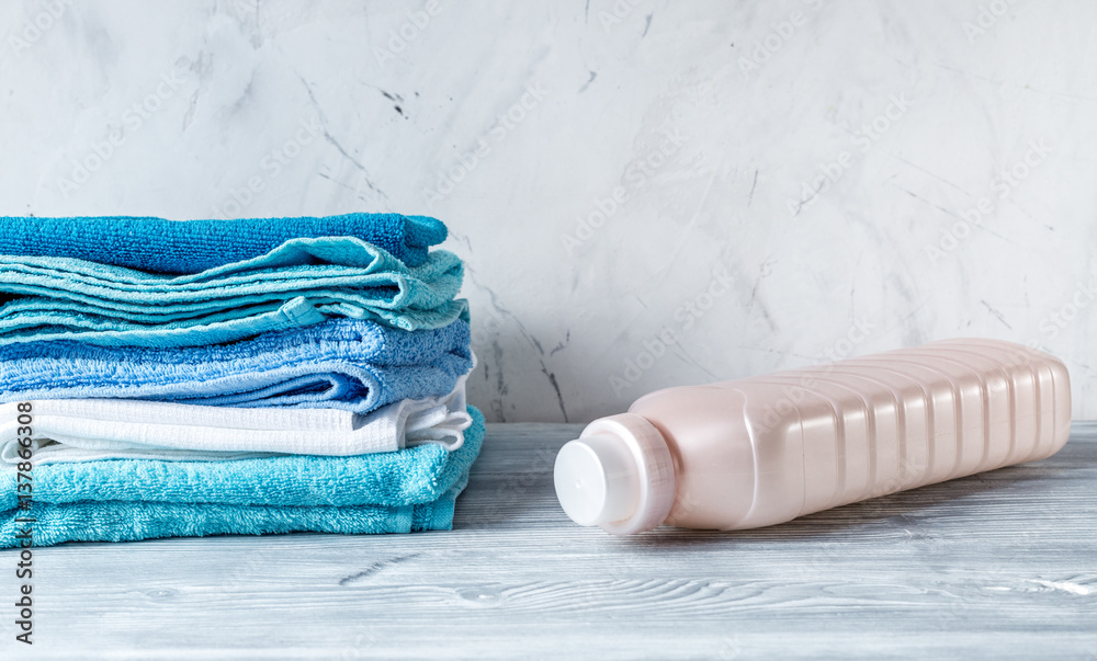 housekeeping set with towels and plastic bottles on laundry background mock-up