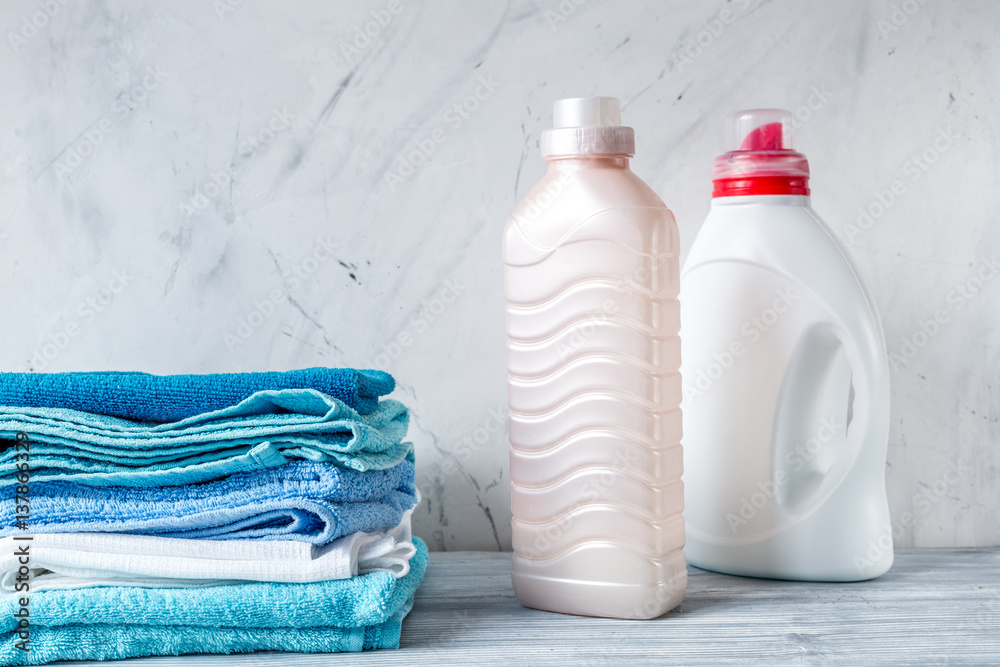 laundry set with towels and plastic bottels on gray background mock up