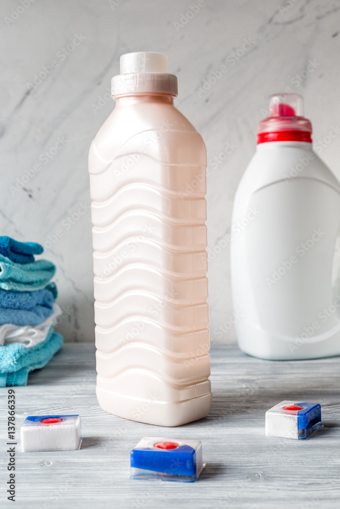 Towels pile with detergent and plastic bottles in laundry