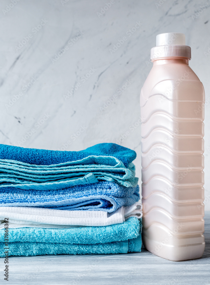 laundry set with towels and plastic bottels on gray background mock up