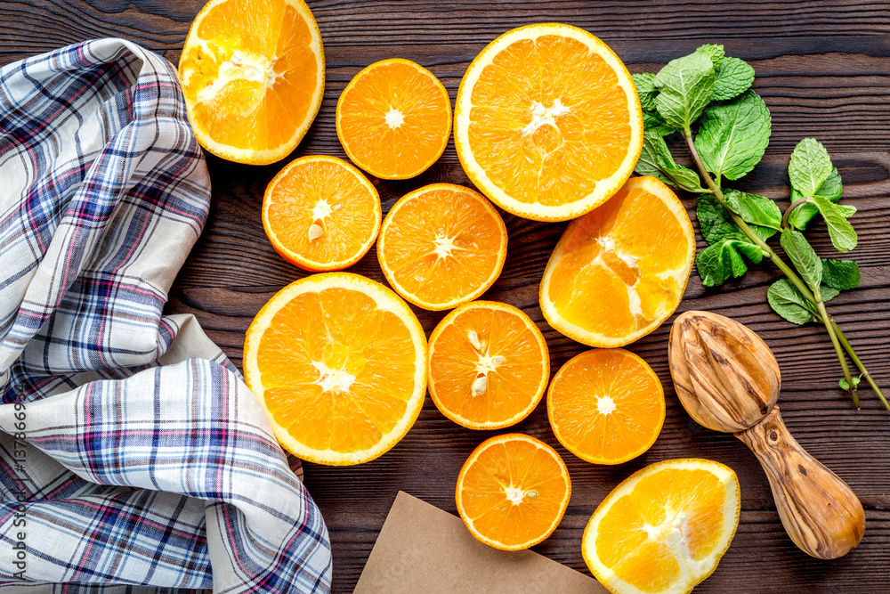 Fresh oranges in slices with mint leaves on kitchen top view