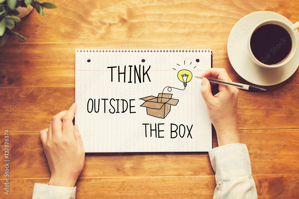 Think Outside The Box text with a person holding a pen