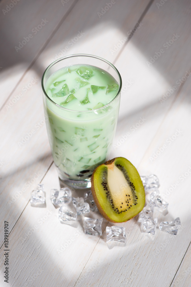 Bubble tea. Homemade Kiwi Milk Tea with Pearls on wooden table.