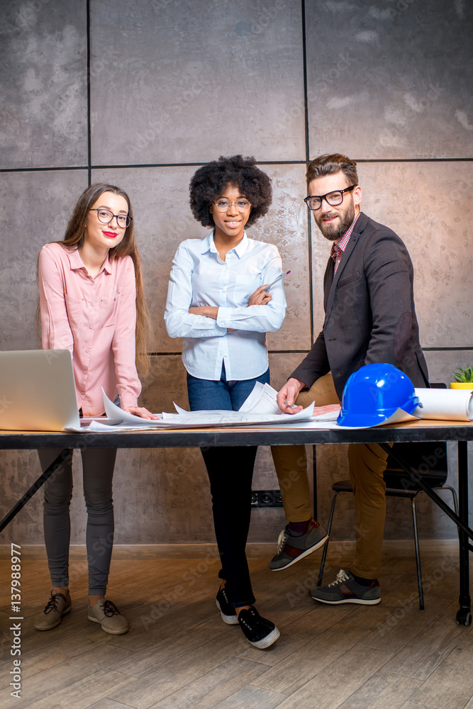 Portrait of multi ethnic group of architects or designers standing together at the office