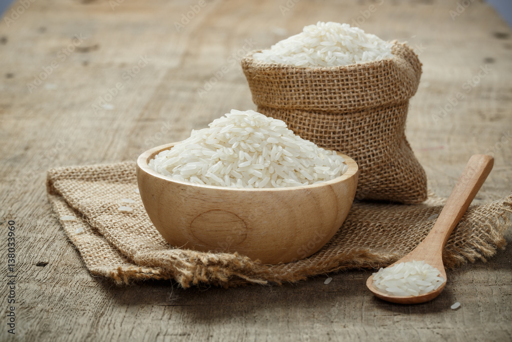 Jasmine Rice in bowl and burlap sack on wooden table