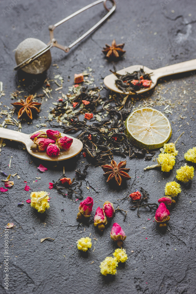 Spoons with herbs on dark background