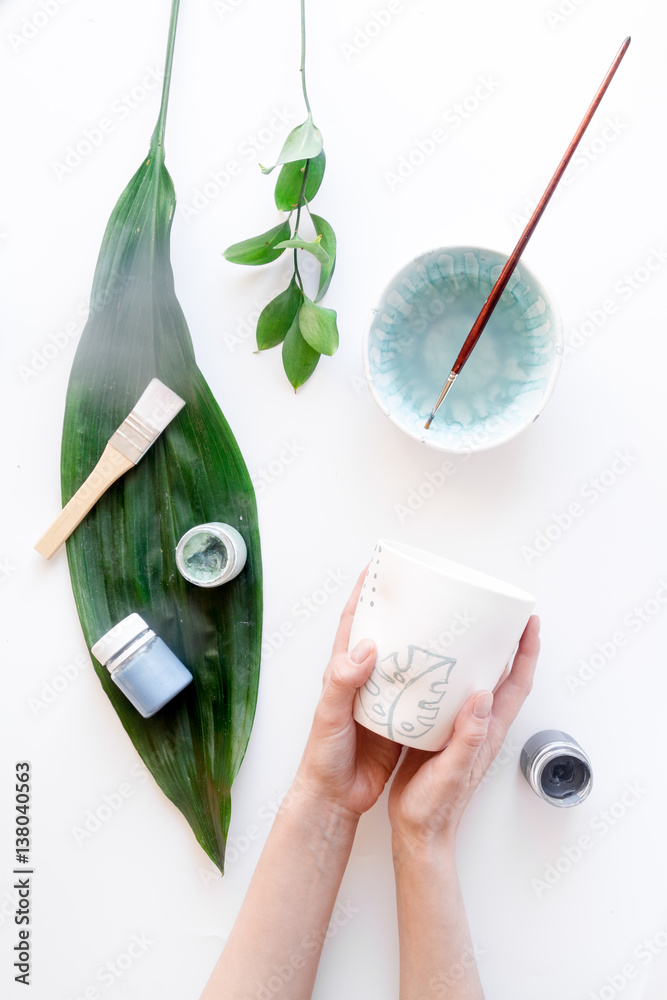 painted ceramic cup on white background top view