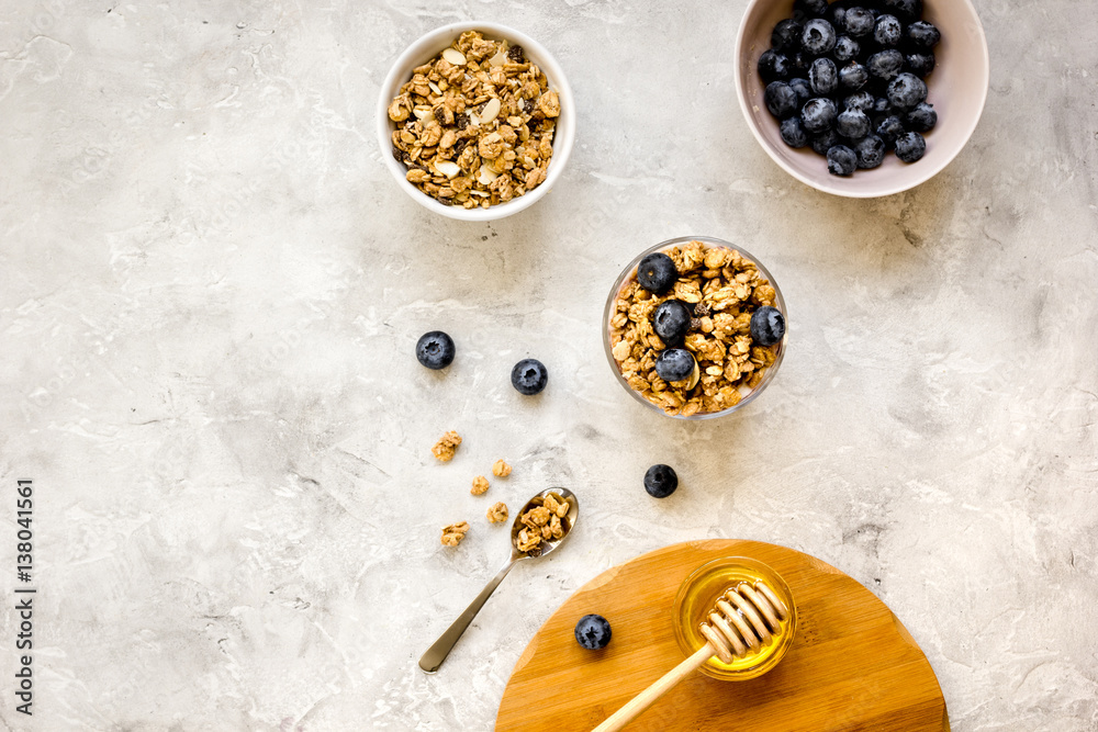 Oat flakes and berries granola glass on table background top view