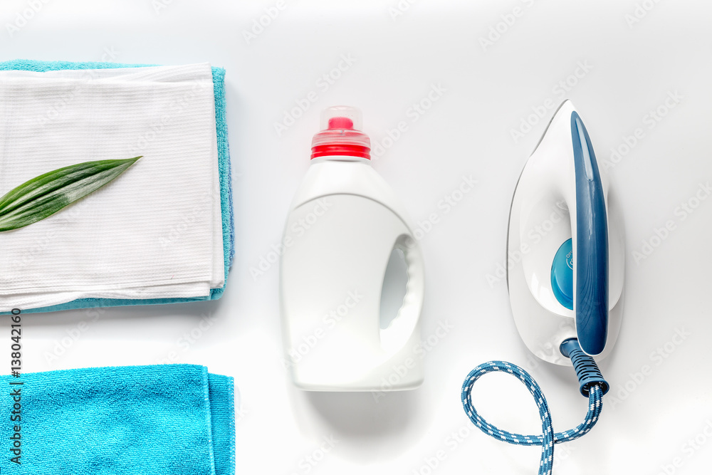 Launry set with towels and iron on white background top view