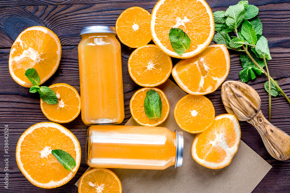 Orange juice in bottle with slices and mint on table top view