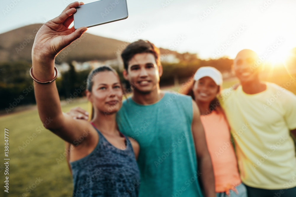 Woman taking selfie with friends at park