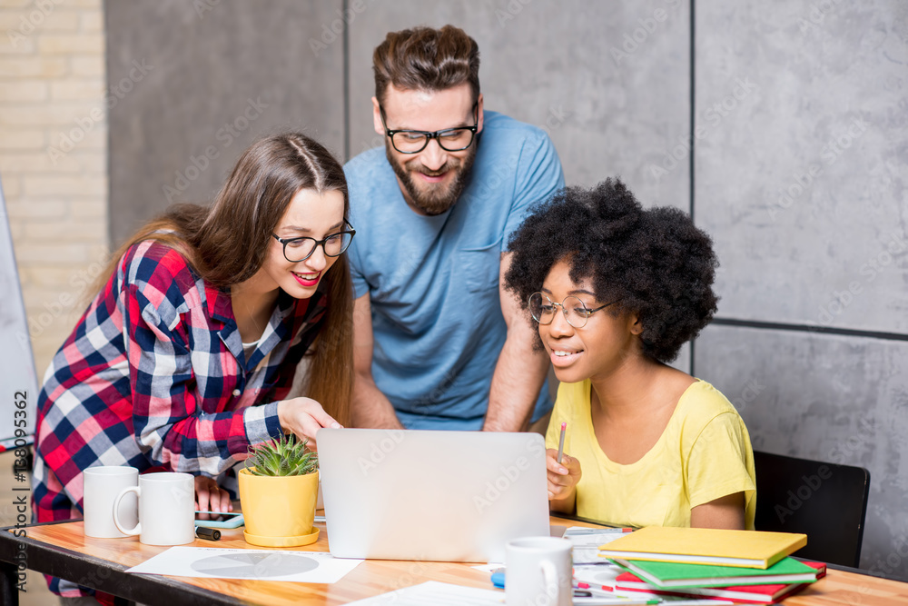 Multi ethnic coworkers dressed casually in colorful clothes working during the meeting at the office