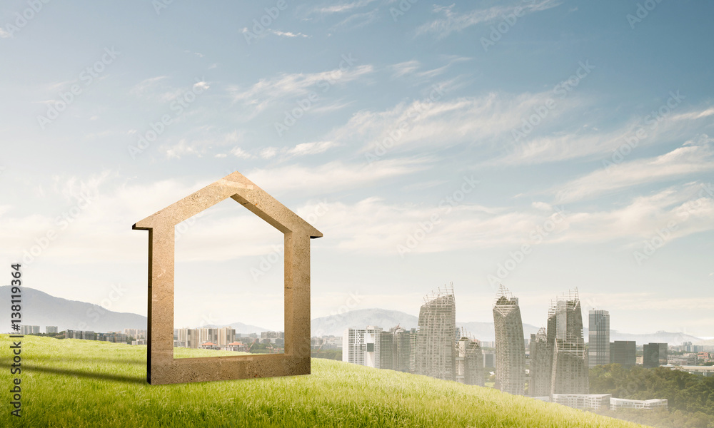 Conceptual image of concrete home sign on hill and natural lands